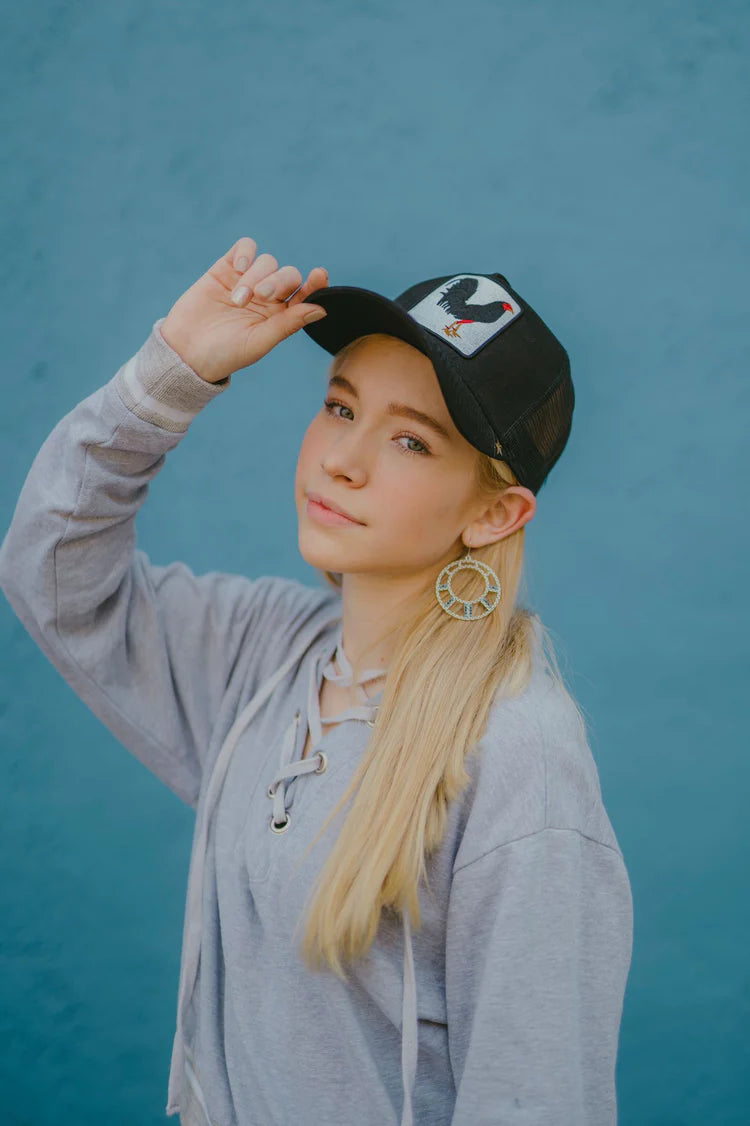 Front view of a woman in the Gold Star Rooster Black Trucker Hat, emphasizing the quality craftsmanship and fashionable appeal