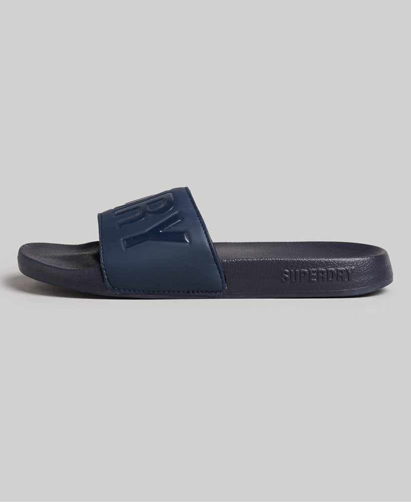 Side view of the Code Core Pool Sliders flattened, revealing their moulded footbed and Superdry branding, providing both comfort and style for sunny days