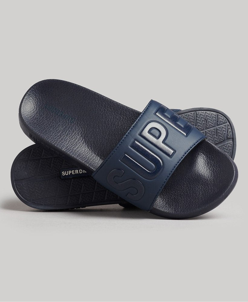 Side view of the Code Core Pool Sliders stacked on top of each other, showcasing their sleek design and cushioned straps, perfect for lounging by the poolside