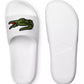 Lacoste Men's Croco 319 4 US CMA Slide Sandals, with one slide facing up and the other facing down, highlighting the durable synthetic construction and rubber sole