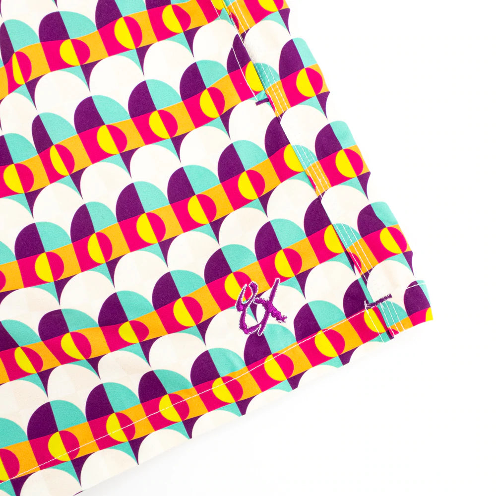 Side view of Sunset Alchemy Swim Trunks, showcasing their vibrant colors and modern design, made from 100% polyester with convenient pockets and a matching drawstring bag