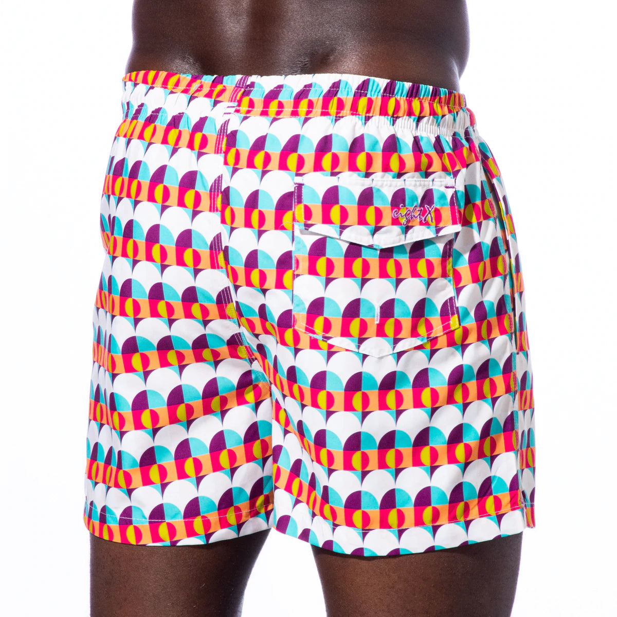 Backside view of Sunset Alchemy Swim Trunks, featuring convenient pockets and a comfortable fit, perfect for beach activities or lounging by the pool