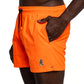 Side view of FROG Swim Trunks in Neon Orange, with the person's hands inside the pocket, highlighting the comfortable fit and above-the-knee length of the swim trunks, perfect for all-day wear